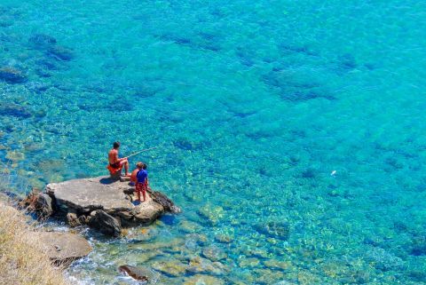 Kids fishing in the crystal clear water of Anafi