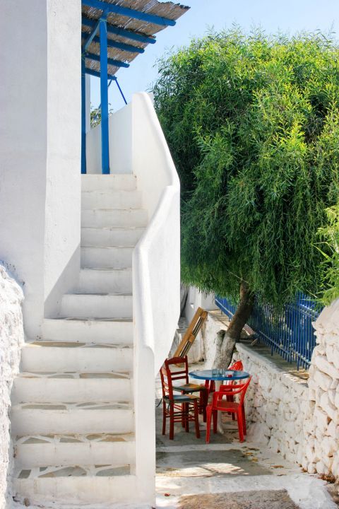 White stairs and outdoor seating of a traditional kafenio.