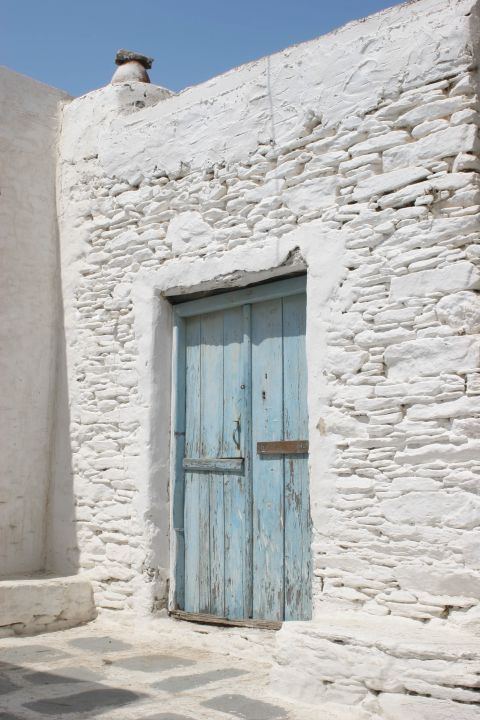 Whitewashed buildings with blue, wooden shutters are spotted everywhere around Chora.
