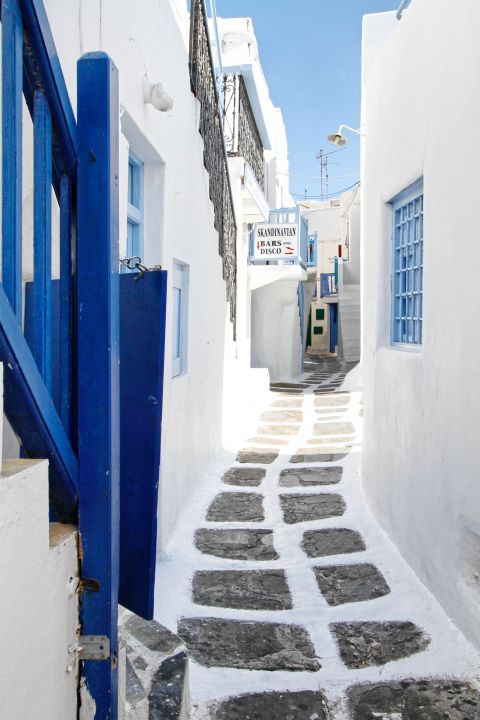 Paved alley with white and blue buildings