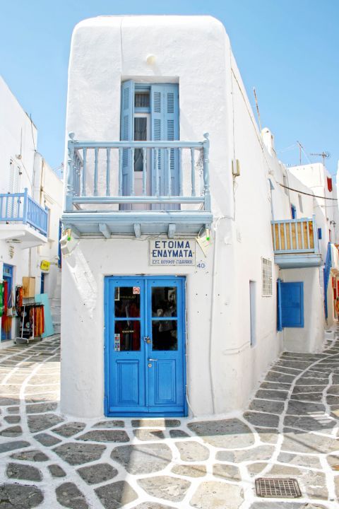 White and blue shop on a paved alley in town