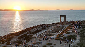 People gathering at Portara (or gate of Apollon) at sunset time