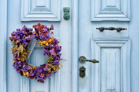 A lovely, blue-colored door, decorated with a wreath.