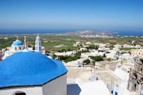 Whitewashed buildings and green fields in Pyrgos village.