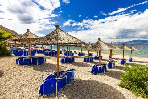 Umbrellas and sun loungers on Molos beach, Hydra