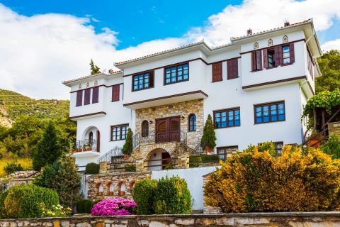 An impressive mansion, surrounded by beautiful flowers in Portaria village.