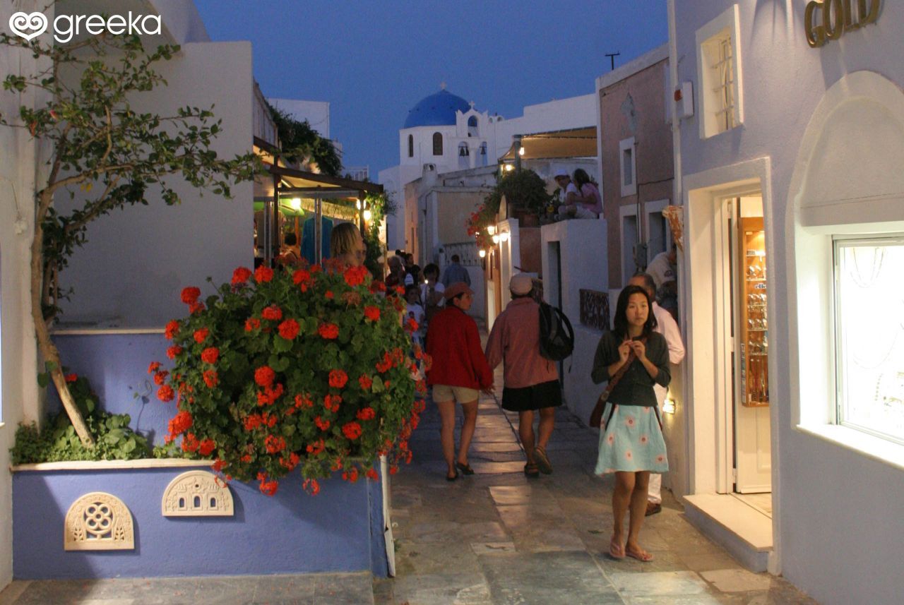 People walking along the picturesque Nikos Nomikos street in Santorini during the late evening