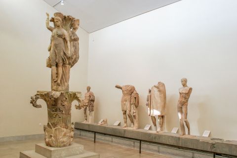 Archaeological Museum: The Dancers of Delphi, also known as the Acanthus Column. Behind it stands the ex voto of Daochos.