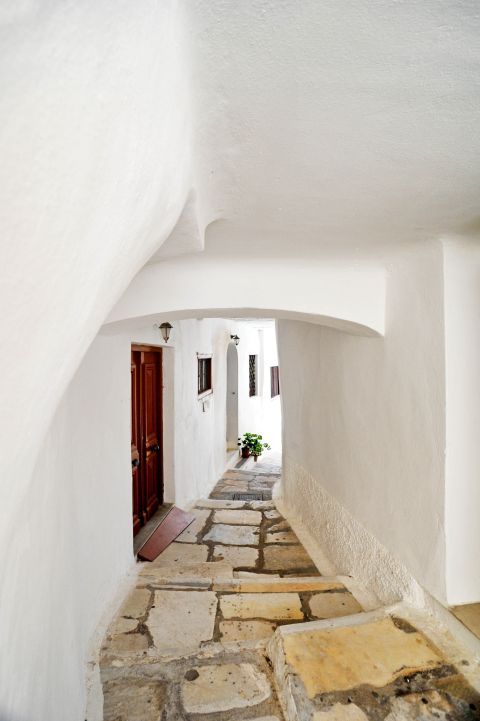 Kastro (Castle): A cobblestone pavement in a whitewashed alley