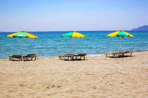 Psilos Gremos: Umbrellas and sun loungers by the sea.