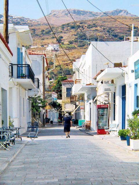 Ormos: A cobblestone street with whitewashed Cycladic buildings