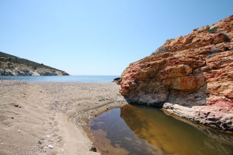 Agios Ioannis: Rocky cliff and sand