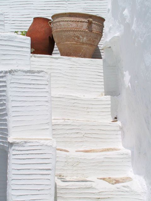 Koumaros: Ceramic vases on whitewashed stairs