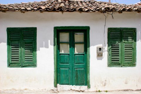 Vassiliki village: A whitewashed house with green-colored details.