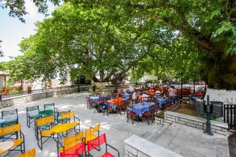 Karia: Taverns and cafes with outdoor seating, placed under big trees.