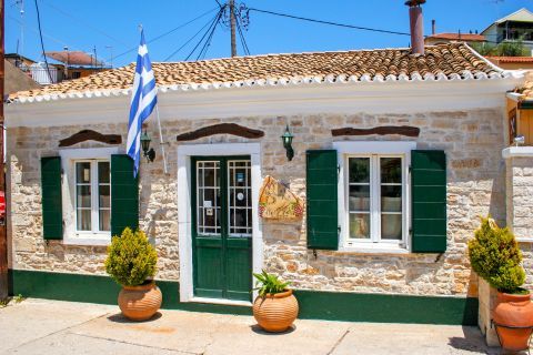 Lakka: Impressive, stone-built building with green shutters and doors.