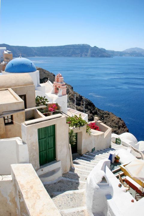 Oia: Light-colored buildings with green or blue details