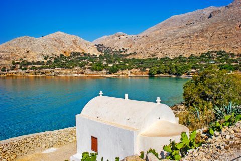 Potamos: A whitewashed chapel, standing on a cliff right above the beach.