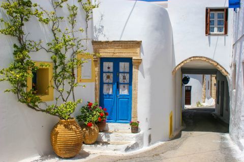 Chora: Whitewashed house with a blue door and cute flowerpots. Kythira Town.