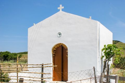 Palamari: A small, whitewashed church with a wooden door.