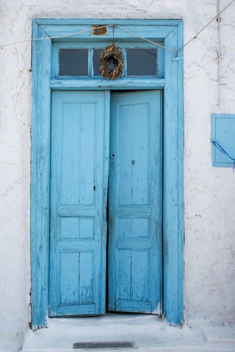 Perdika: A blue-colored door on a whitewashed house.