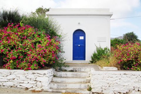 Kalofana: A whitewashed house with a blue-colored door
