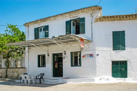 Agios Leon: Whitewashed building with green colored shutters.
