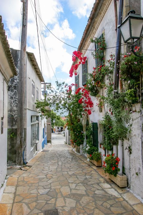 Liapades Village: An old mansion in white and green colors, decorated with lovely flowers.