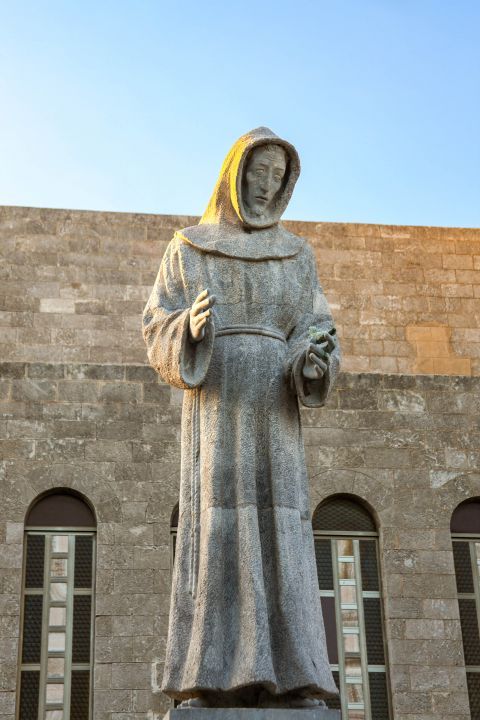 Town: Statue of Francis Assisi in front of the Catholic Church of Agios Frangiskos.