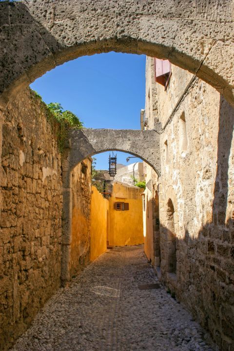 Town: A narrow path with stone built arches.