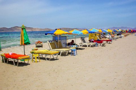 Marmari: Umbrellas and sun loungers by the sea.