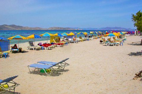 Marmari: Sandy beach with umbrellas and sun loungers.