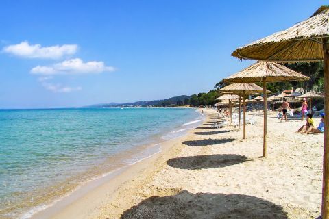 Kriopigi: Relax under the refreshing shade of an umbrella, on the sea side of Kriopigi beach.