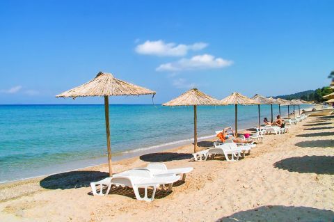 Kriopigi: Some umbrellas and sun loungers are spotted all over the shore of Kriopigi beach.