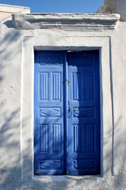 Karterados: A whitewashed Cycladic house with a blue-colored door