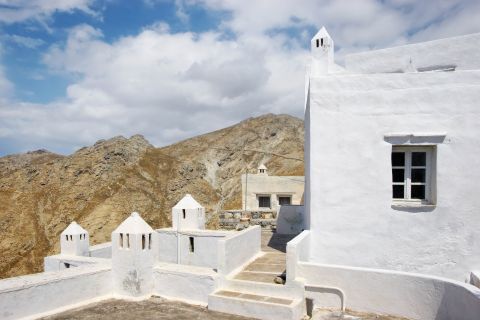 Chora: Whitewashed construction with some barren hills on the background.
