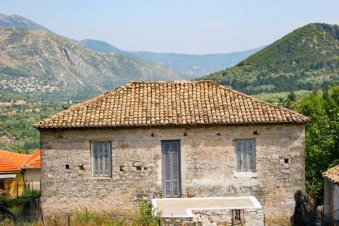 Poros: An old house with ceramic roof tiles. It offers magnificent view to green hills and mountains.