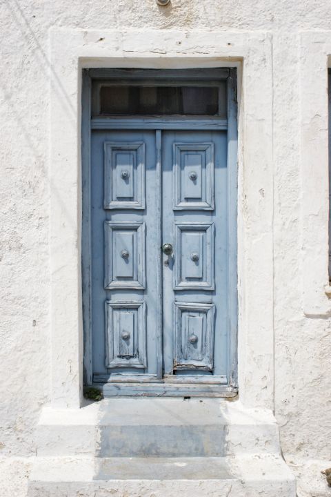 Chora: Blue-colored, wooden door with lovely shapes.