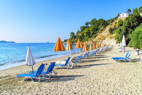 Vassilias: Umbrellas and sun loungers by the sea.
