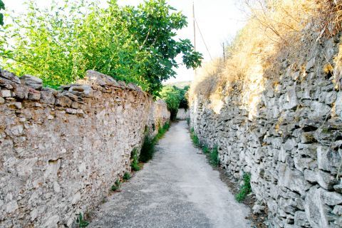 Potamia: The stone built walls of a narrow alley