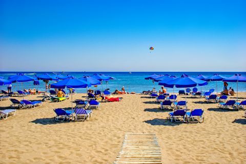 Faliraki Beach: Blue colored umbrellas and sun loungers on Faliraki beach.