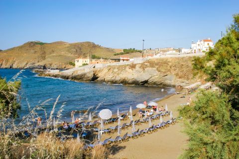 Panormos: Umbrellas and sun loungers on the beachfront of Panormos beach.